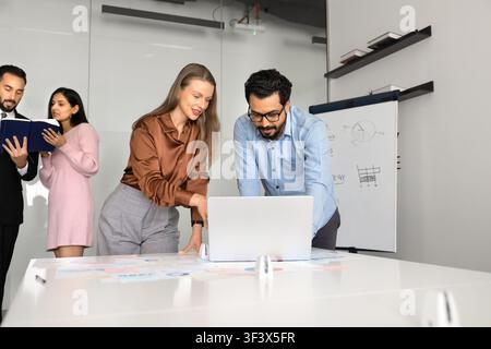 Business team analyzing financial data on laptop Stock Photo