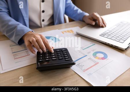Accountant using calculator, working with financial documents and laptop, closeup Stock Photo