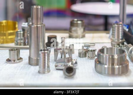 A display of various precision-machined stainless steel and metal industrial fittings, connectors, and components, commonly used in hydraulic, pneumat Stock Photo