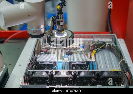 Close-up of an automated industrial robotic arm equipped with a high-resolution machine vision camera and LED ring light inspecting the internal compo Stock Photo