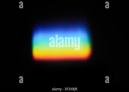 Light refracting through prism creating colorful spectrum effect on black background Stock Photo