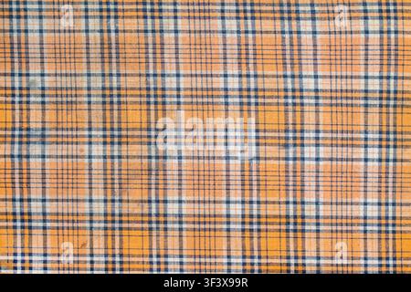 The texture of old plaid fabric. Yellow checkered fabric. Stock Photo