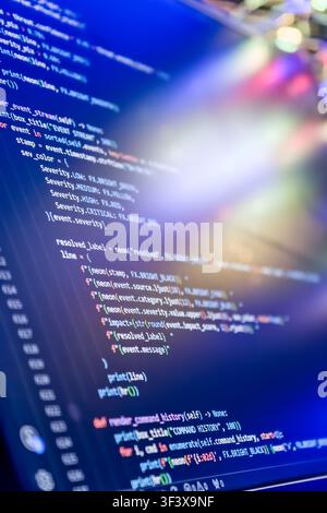 Abstract futuristic programming code on computer screen. Macro shot of a dark mode IDE with python script, cybersecurity threat analysis, and colorful Stock Photo