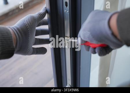 Person using screwdriver to unlock door Stock Photo