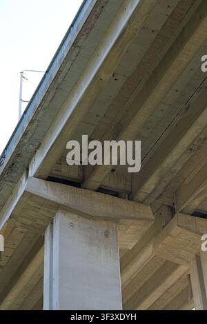 Concrete bridge beams and pillars forming a sturdy infrastructure, showcasing modern engineering and construction details from a low angle view lookin Stock Photo