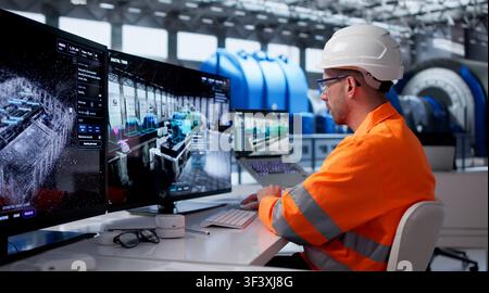 Young Engineer Monitors Real-time Industrial Data On Smart Control Room Screens. Stock Photo