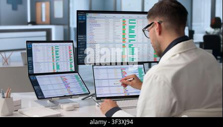 Healthcare Analyst Uses Dual Touchscreen Laptop To Review Billing Codes Efficiently. Stock Photo