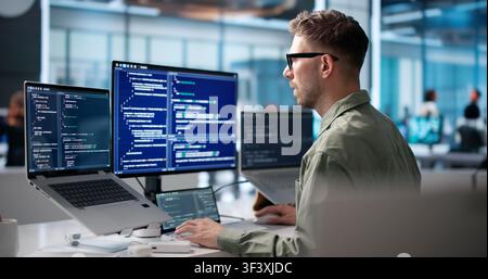 Young Software Engineer Coding On Laptop To Build Secure Business Platform. Stock Photo