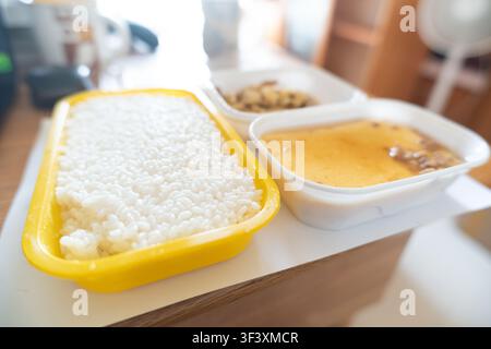 Japanese bento box with steamed rice, miso soup, and side dish served on wooden table in Tokyo, Stock Photo