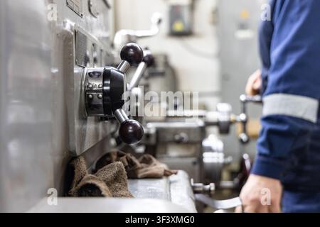 Industrial lathe machine operator working in metal machining workshop Stock Photo