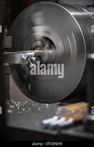 Precision metal turning on industrial lathe machine in manufacturing workshop Stock Photo