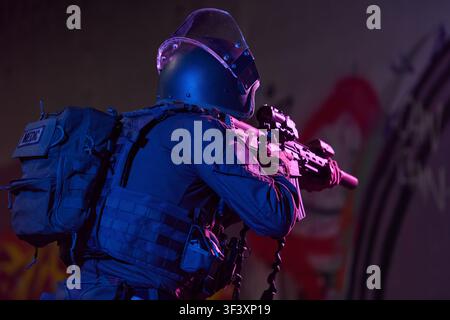 Tactical SWAT Operator Medic With Rifle Aiming During Night Urban Police Special Forces Operation Stock Photo
