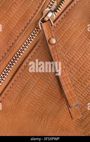 Zipper fastener in brown textured leather closeup as a background Stock Photo