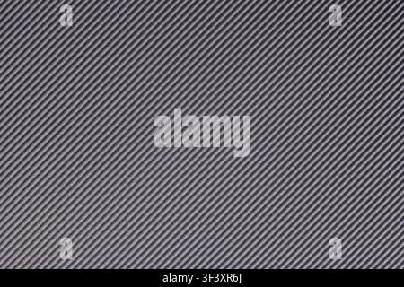 Close-up shot of a dark grey surface featuring a diagonal ribbed texture. The subtle sheen enhances the visual depth, making it ideal for various desi Stock Photo