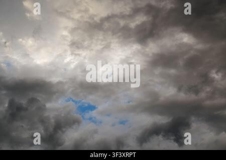 Dramatic storm clouds, sky, celestial landscape with clouds in the background and blue gaps Stock Photo