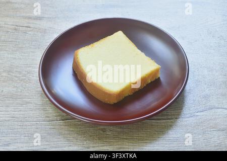 butter vanilla cheesecake cutting in square shape on plate Stock Photo
