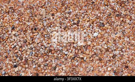 Coarse sand and small colorful pebbles texture background, top view of gravel surface. Stock Photo