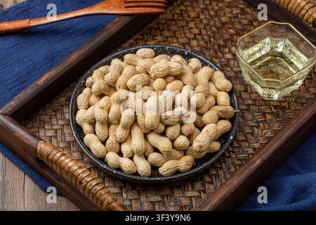 Roasted peanuts in shell served on blue dish Stock Photo