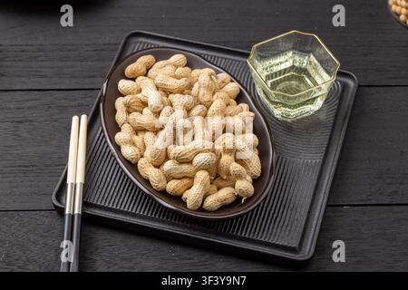 Roasted peanuts in shell served on blue dish Stock Photo