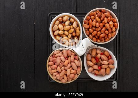 Assorted peanut dishes including vinegar soaked fried and boiled peanuts in four compartments Stock Photo