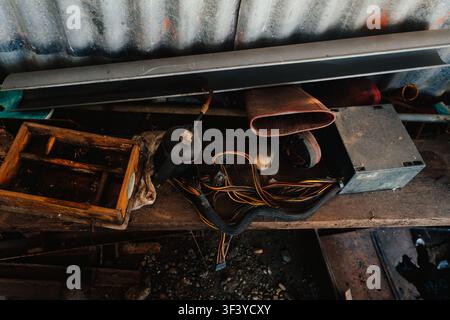 Cluttered workbench with old tools, wooden box, and computer cables in a garage Stock Photo