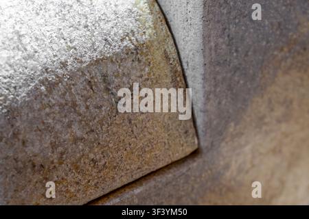 Extreme close-up of weathered stone tile corner with granular texture, brown and gray tones, shallow depth of field, abstract background Stock Photo