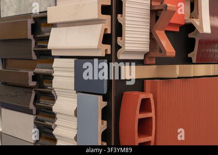 Angled close-up of assorted facade cladding samples, white blue and terracotta panels, construction material showroom display Stock Photo