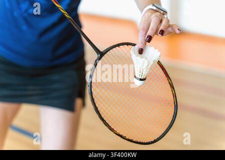 Woman preparing to serve with shuttlecock and racket on badminton court, close-up Stock Photo