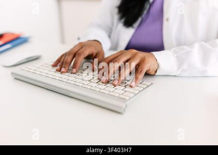 Indian nutritionist typing on keyboard during online consultation Stock Photo