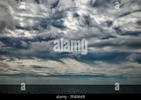 Dramatic stormy looking clouds of silver and grey gather over a grey sea, Bournemouth, Dorset, England. Stock Photo