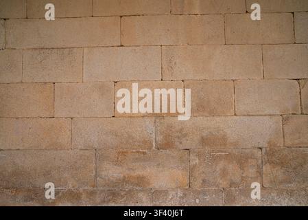 Blank architectural surface showing rough stone textures and horizontal cement lines in warm natural sunlight Stock Photo