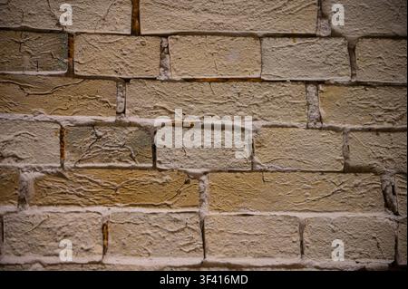 A close-up view of an old, weathered brick wall with visible mortar lines and subtle color variations Stock Photo
