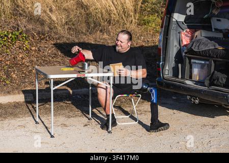 Man with prosthetic leg enjoying van life coffee Stock Photo