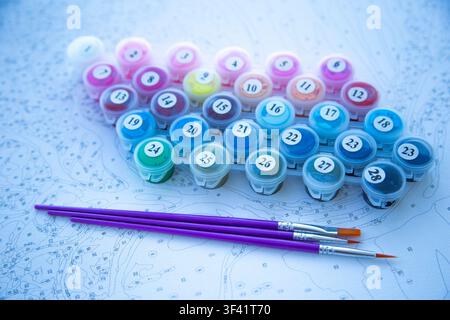 Close-up of an angled painting kit showing multi-colored acrylic paint jars from 1 to 28 and three Stock Photo