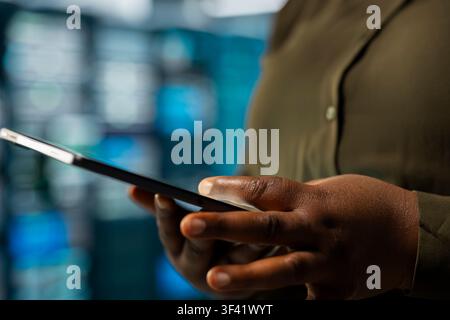 Close up of engineer implementing security measures integral to fortifying data center defenses against cyber threats. Server hub worker doing threat detection, defending company systems Stock Photo