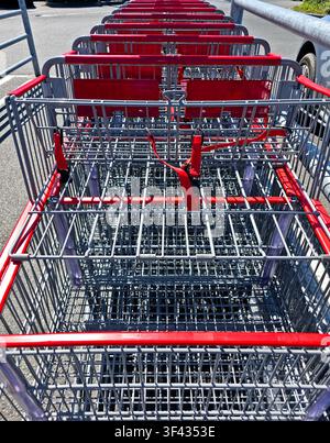 Empty Shopping Carts Lined Up Outside Supermarket with Red Handles and Perspective View Stock Photo
