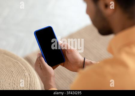 Unrecognizable Man Holding Smartphone With Blank Screen At Home, Technology Concept Stock Photo