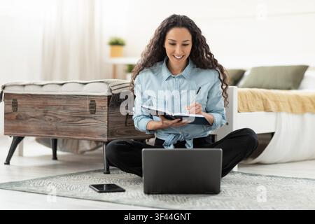 Smiling Young Black Woman Studying And Taking Notes At Home, Cozy Atmosphere, Education Concept Stock Photo
