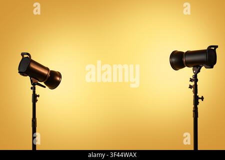Two studio strobe lights on stands illuminating a warm yellow gradient background with copy space Stock Photo