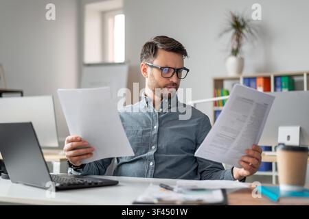 Focused Man Analyzing Documents At Home Office, Business Concept Stock Photo