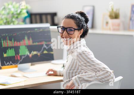 Smiling Latin American Woman Working On Computer In Office, Business Concept Stock Photo