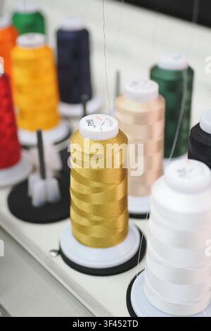 Spools of thread in different colors on a work table Stock Photo