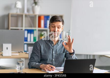 Focused Caucasian Male Professional Engaging In Virtual Meeting At Office, Business Concept Stock Photo
