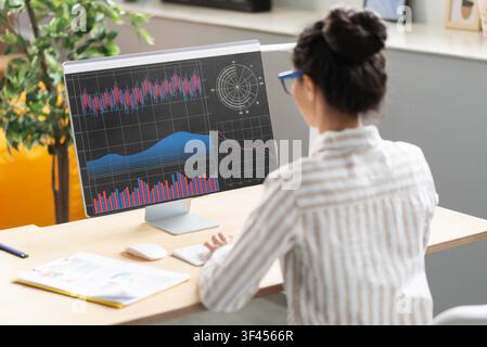 Unrecognizable Female Analyzing Data On Computer In Modern Office, Business Concept Stock Photo
