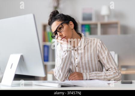 Thoughtful Young African American Woman Working At Computer In Office, Remote Work Concept Stock Photo