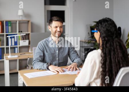 Smiling Man And Woman Having Conversation In Modern Office, Business Concept Stock Photo