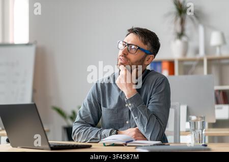 Thoughtful Caucasian Man Wearing Glasses In Office, Thinking About Ideas, Business Concept Stock Photo