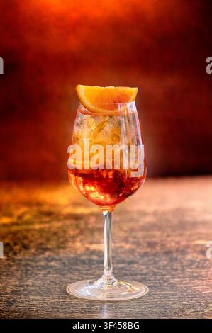 Fizzy Aperol Spritz cocktail with ice and an orange slice on a bar table Stock Photo