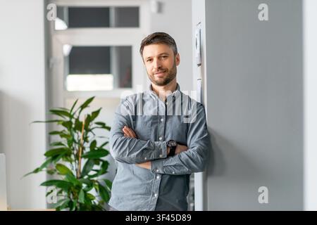Confident Young Caucasian Man Standing In Office, Business Concept Stock Photo