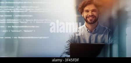 Smiling Young Caucasian Male Developer Working At Laptop In Modern Office, Business Concept Stock Photo